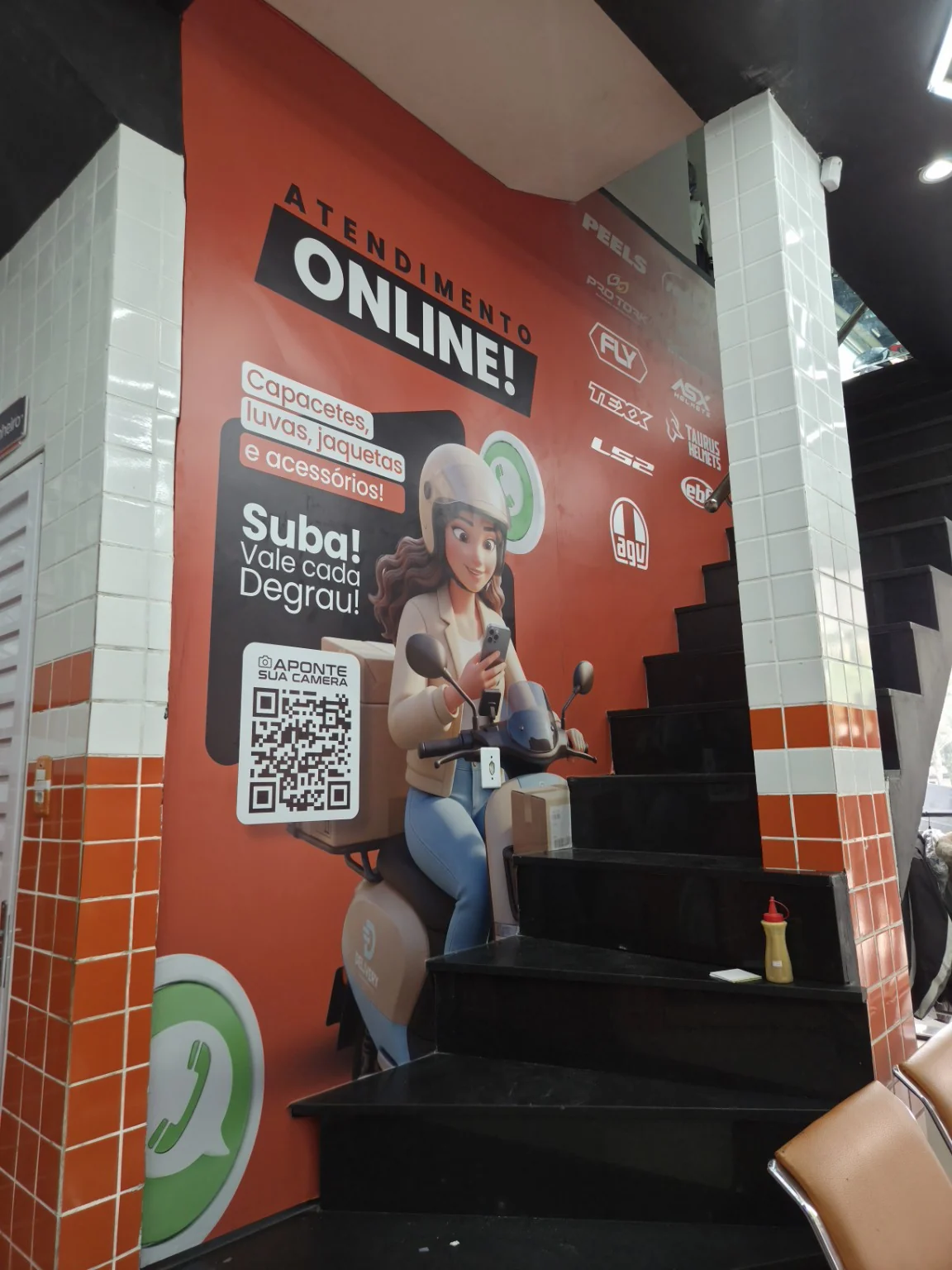 Adesivo de divulgação do atendimento online aplicado junto à escada.
