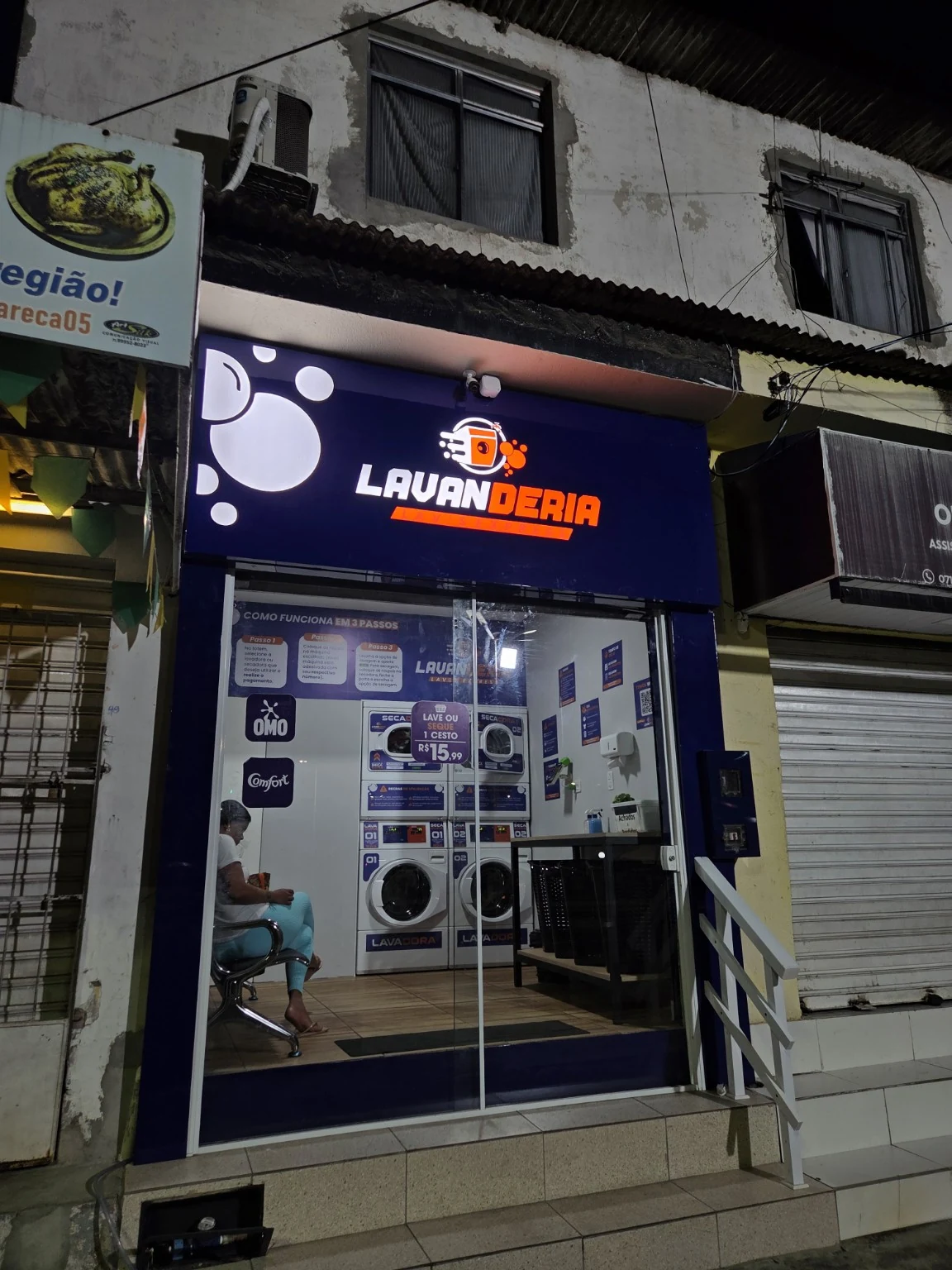 Fachada de lavanderia com painel de identificação e comunicação nas portas de vidro