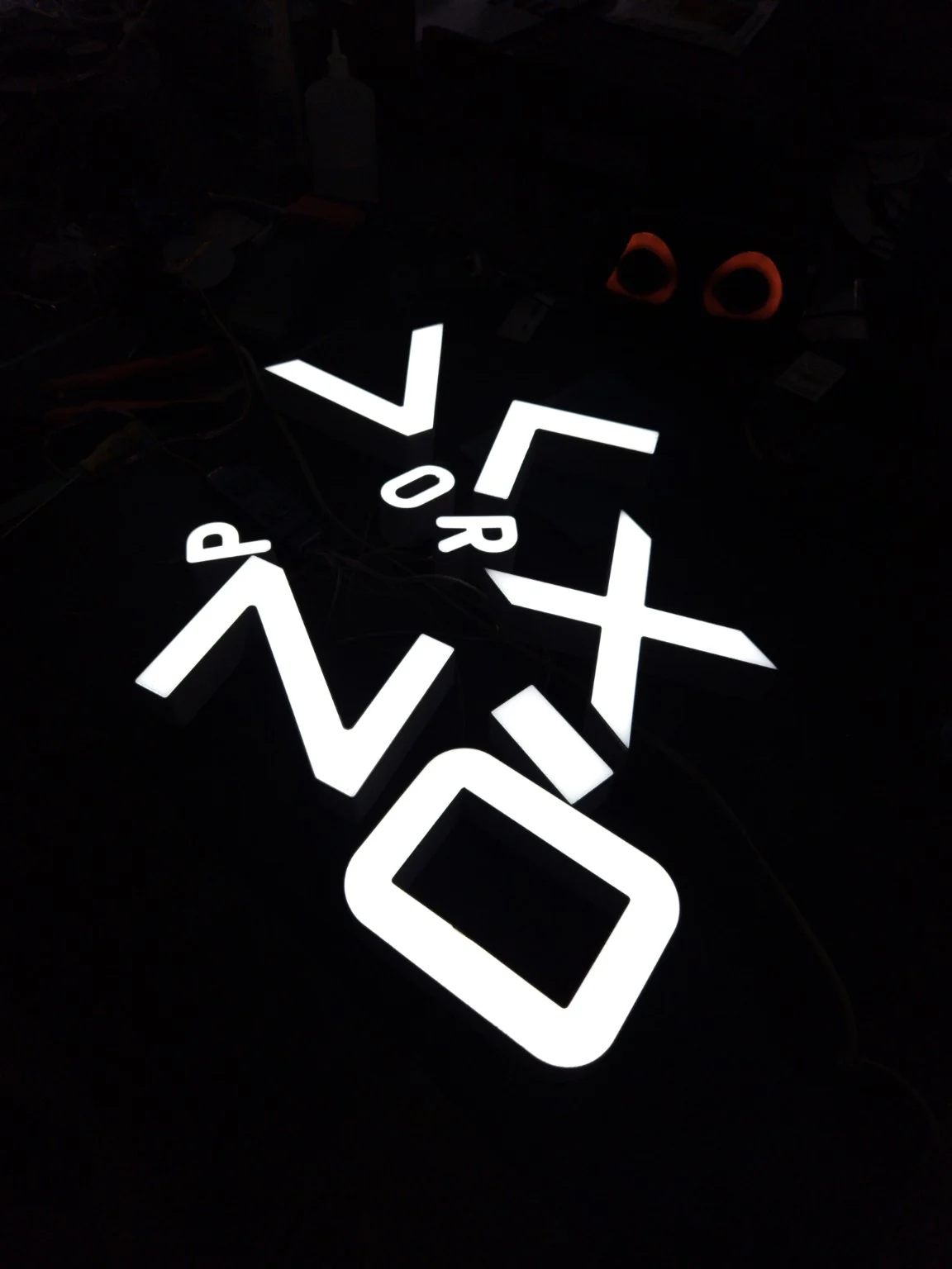 Letras com iluminação frontal durante o teste na bancada de produção.